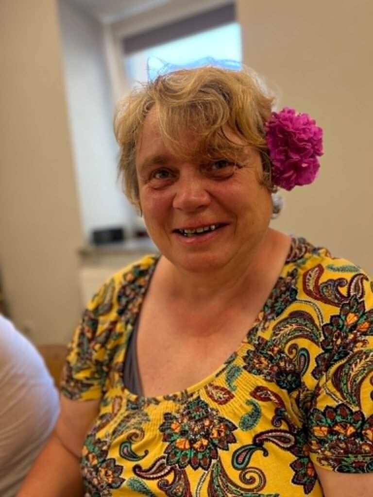 Dalyvė šypsosi šalia surinktų hortenzijų