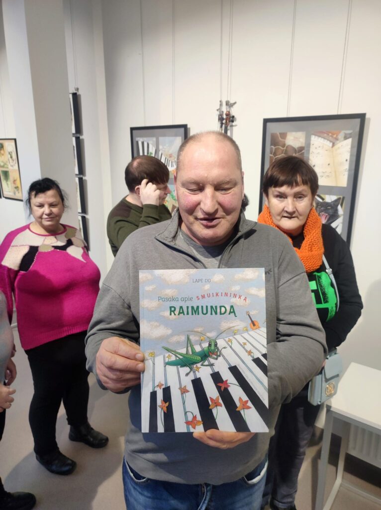 Dalyvis galerijoje rodo leidinį „Paminda“