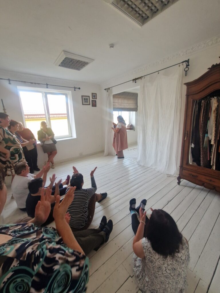 Participants in the theatre workshop watch a couple’s improvisation