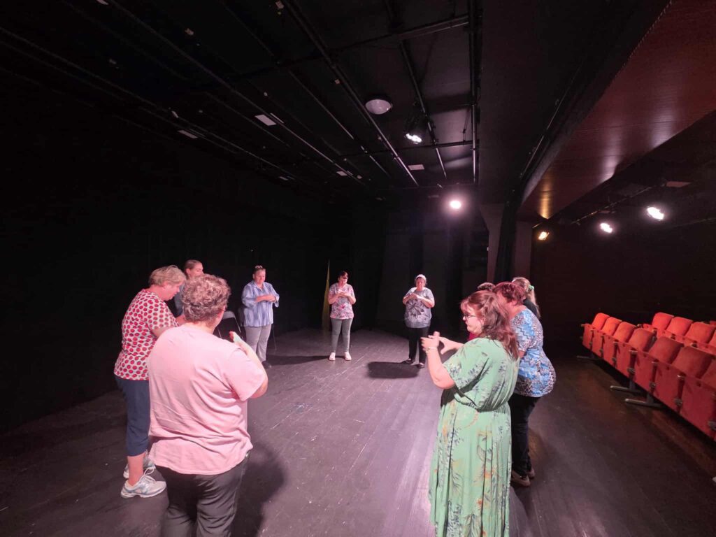 A theatre group is performing a movement improvisation on stage