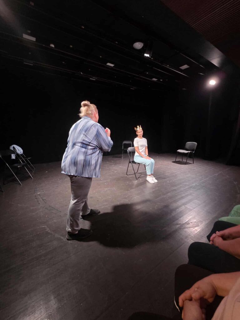 A participant performs a scene in front of the group