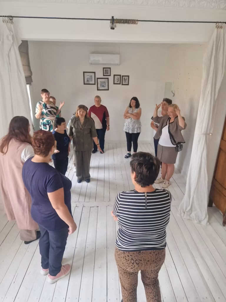 Užsiėmimo vadovė aptaria pratimą su teatro grupe